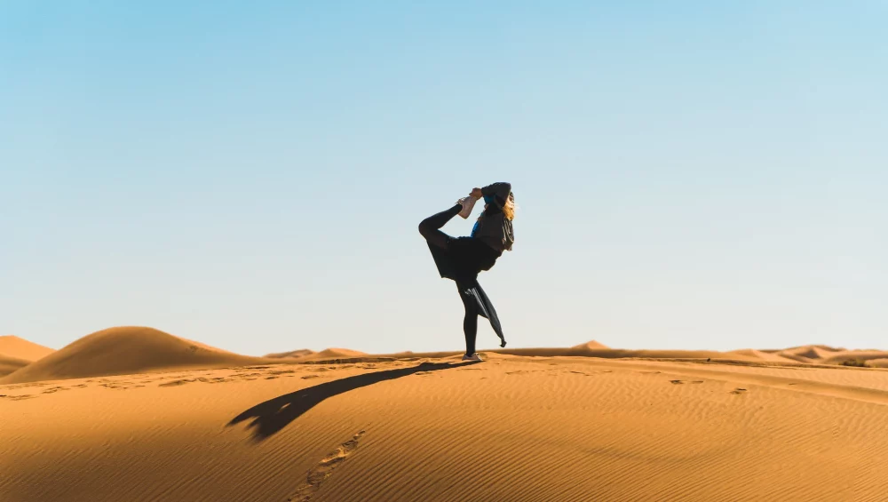 Femme pratiquant le yoga dans les dunes du désert de M’Hamid