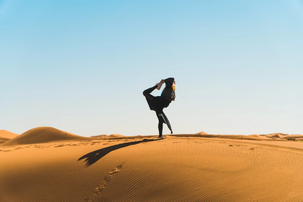 Femme pratiquant le yoga dans les dunes du désert de M’Hamid