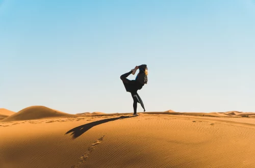 Femme pratiquant le yoga dans les dunes du désert de M’Hamid